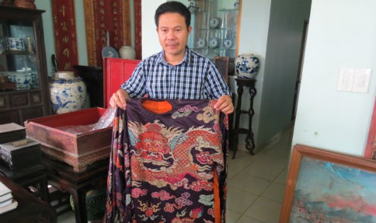 Nhà sưu tầm Nguyễn Hữu Hoàng bên cạnh chiếc áo của một vị quan triều Nguyễn