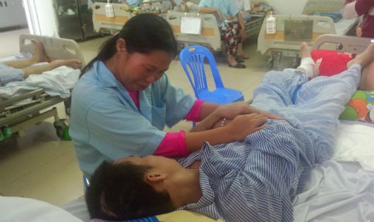 Chị Nguyễn Thị Hằng bên giường bệnh của chồng