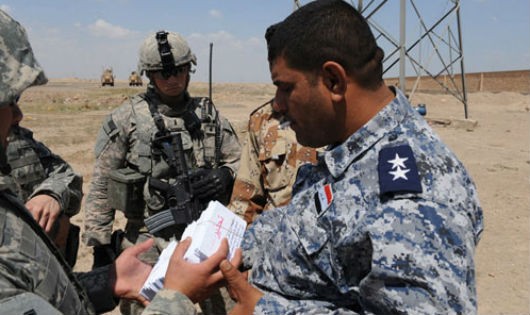 Nhân viên Sgt. Michael Bautista từ Công ty Điều hành 301 Tâm lý, tờ rơi tay cho một sĩ quan cảnh sát Iraq để tặng cho những người dân địa phương, vào ngày 10/4/2009, tại Baghdad, Iraq. (Nguồn: psywar.org)