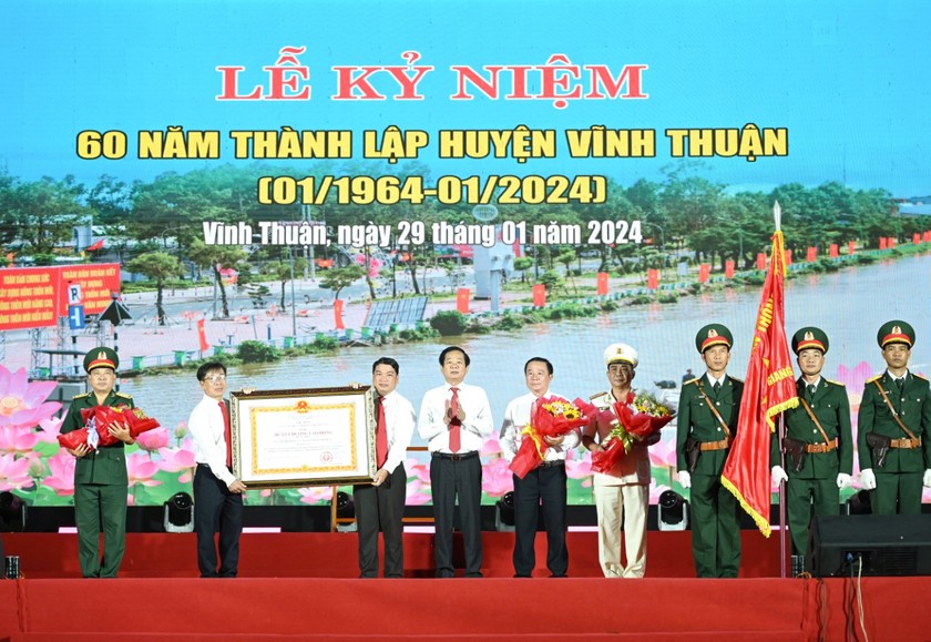 Thừa ủy quyền của Chủ tịch nước, ông Đỗ Thanh Bình - Bí thư Tỉnh ủy Kiên Giang (thứ 4, từ trái qua) trao Huân chương Lao động hạng Nhất cho Đảng bộ, chính quyền và Nhân dân huyện Vĩnh Thuận.