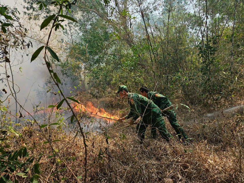Cán bộ, chiến sĩ Đồn Biên phòng CKQT Tịnh Biên tích cực giúp dân chữa cháy.